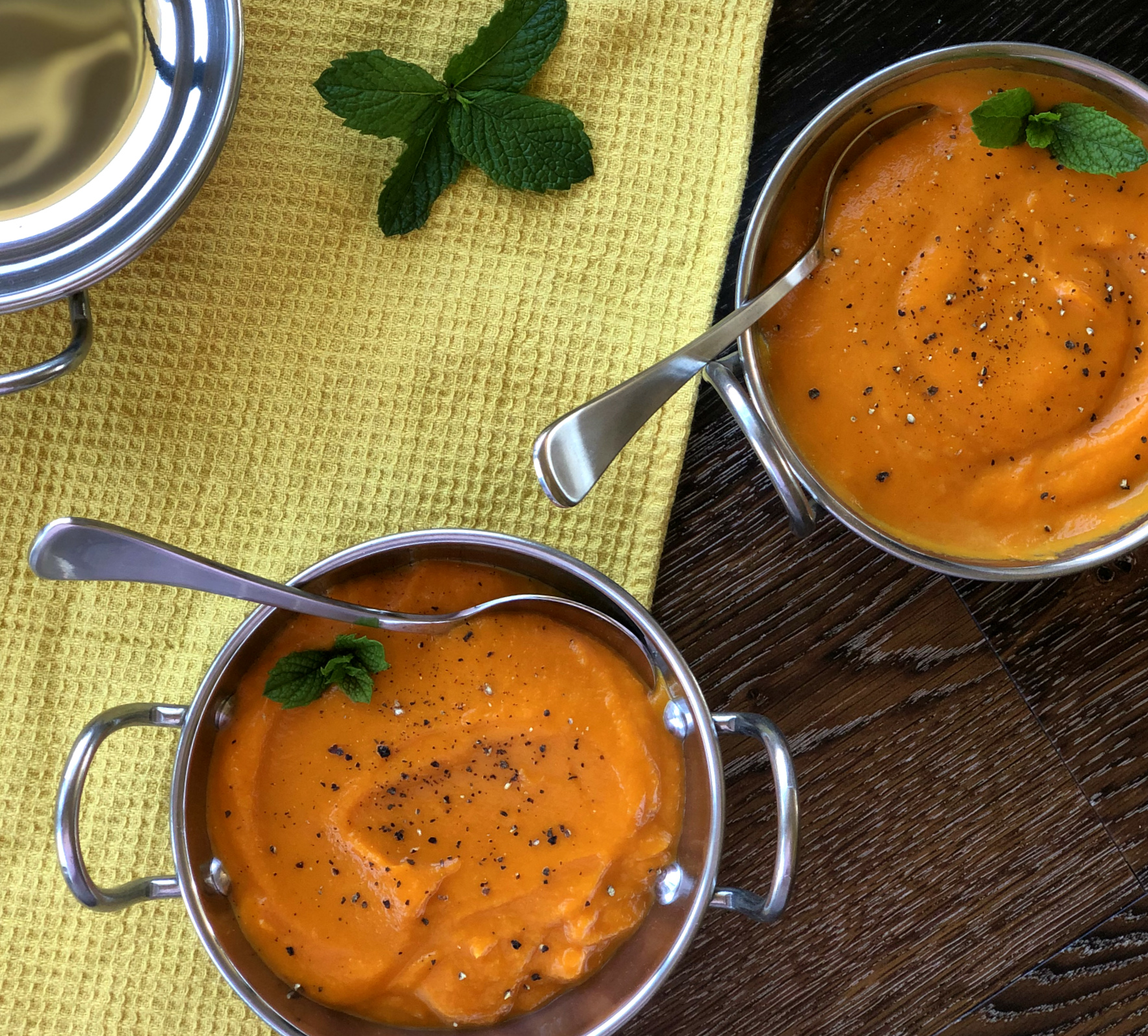 Carrot & Ginger Soup in two Bowls with cracked pepper to serve 