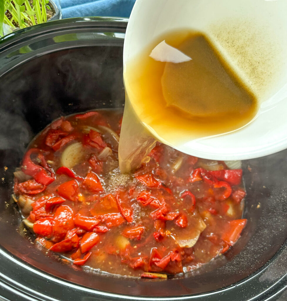 Pouring cornstarch slurry to thicken slow cooker tomato soup