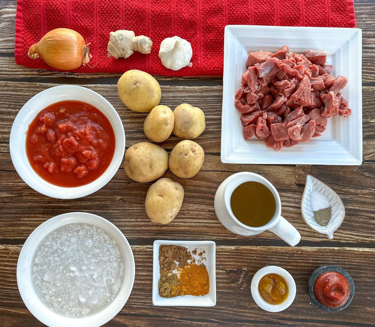 Ingredients for a slow cooker lamb and potato curry - see recipe card for full details