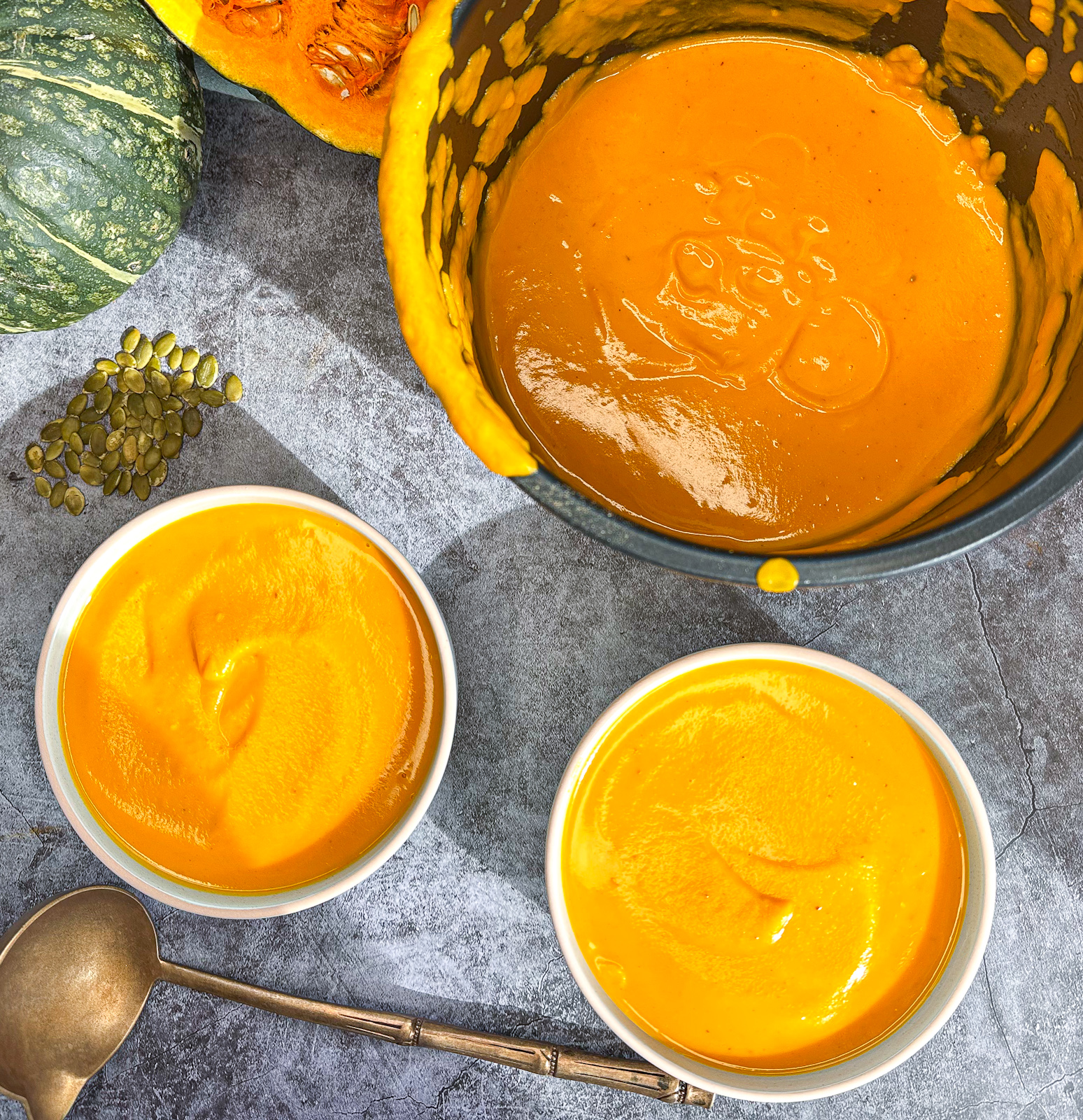 Slow Cooker bowl, blended pumpkin soup and served into two bowls with fresh pumpkin