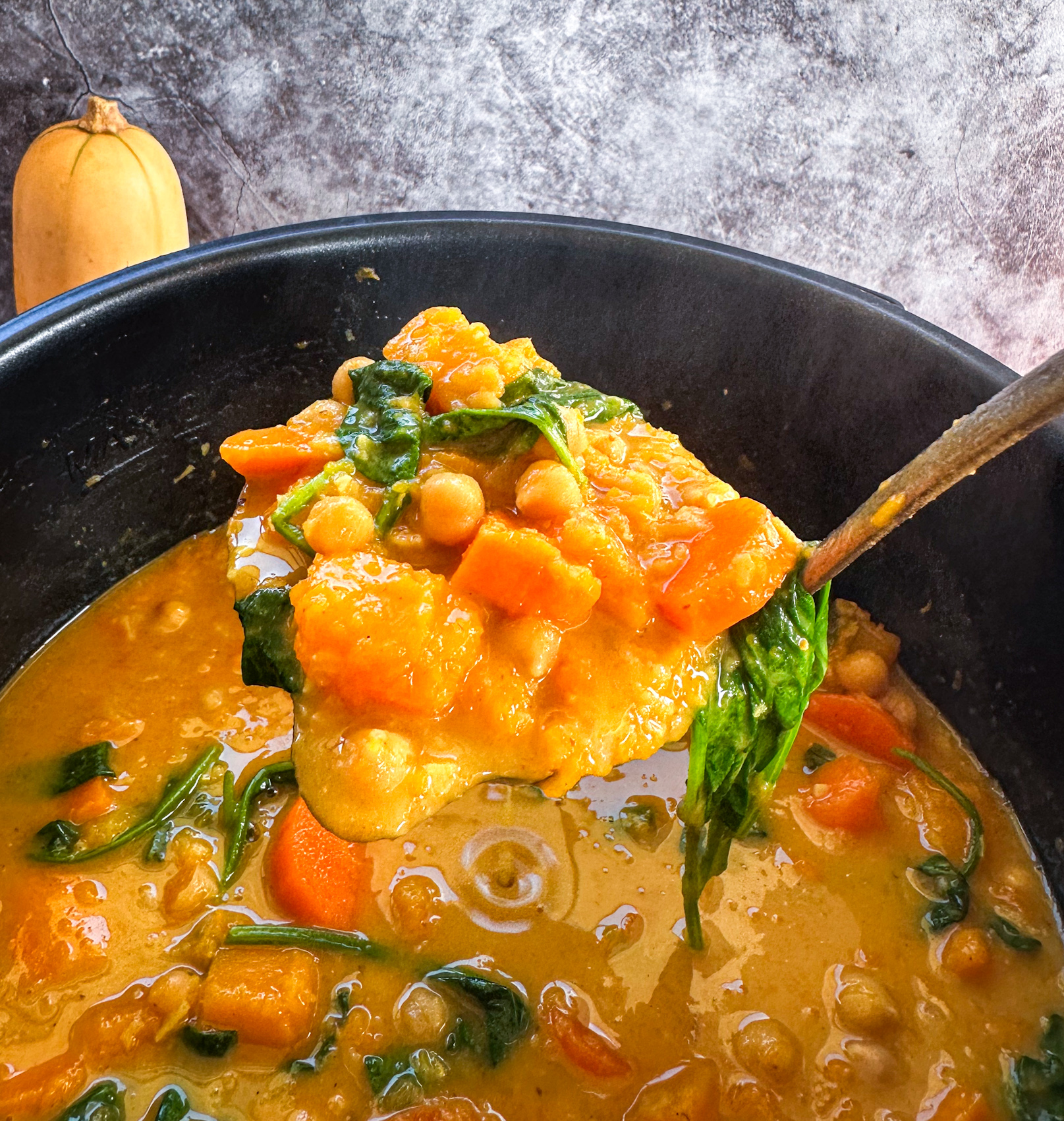 A scoop of slow cooker pumpkin and chickpea curry