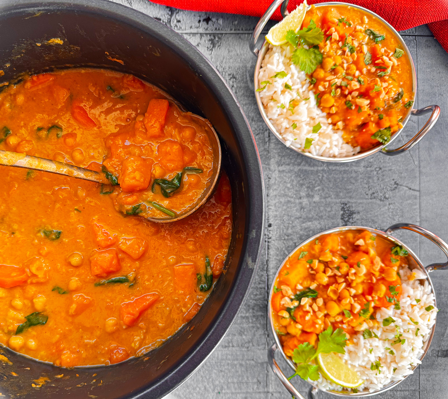 Slow cooker full of pumpkin and chickpea curry and two bowls prepared with rice, lime and coriander