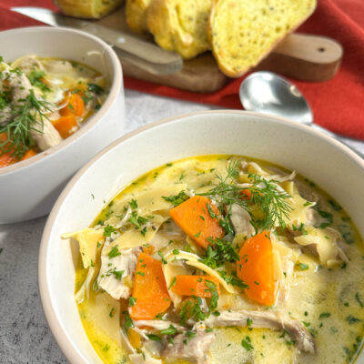 Creamy Slow Cooker Chicken Noodle soup in a bowl with crusty bread