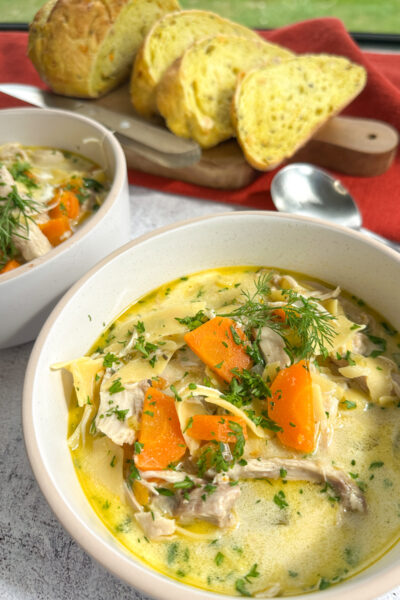 Creamy Slow Cooker Chicken Noodle soup in a bowl with crusty bread