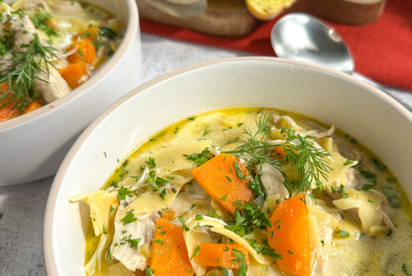 Creamy Slow Cooker Chicken Noodle soup in a bowl with crusty bread