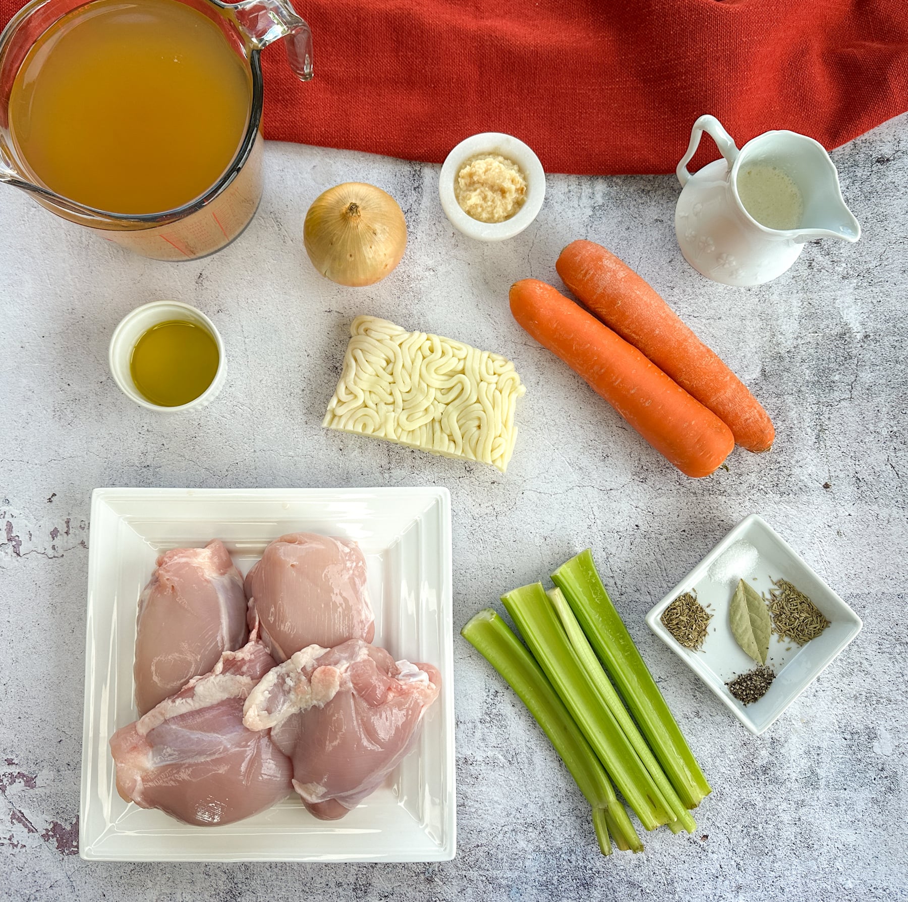 Cozy Creamy Slow Cooker Chicken Noodle Soup Ingredients used to make slow cooker chicken soup such as chicken thighs, cream, broth and vegetables