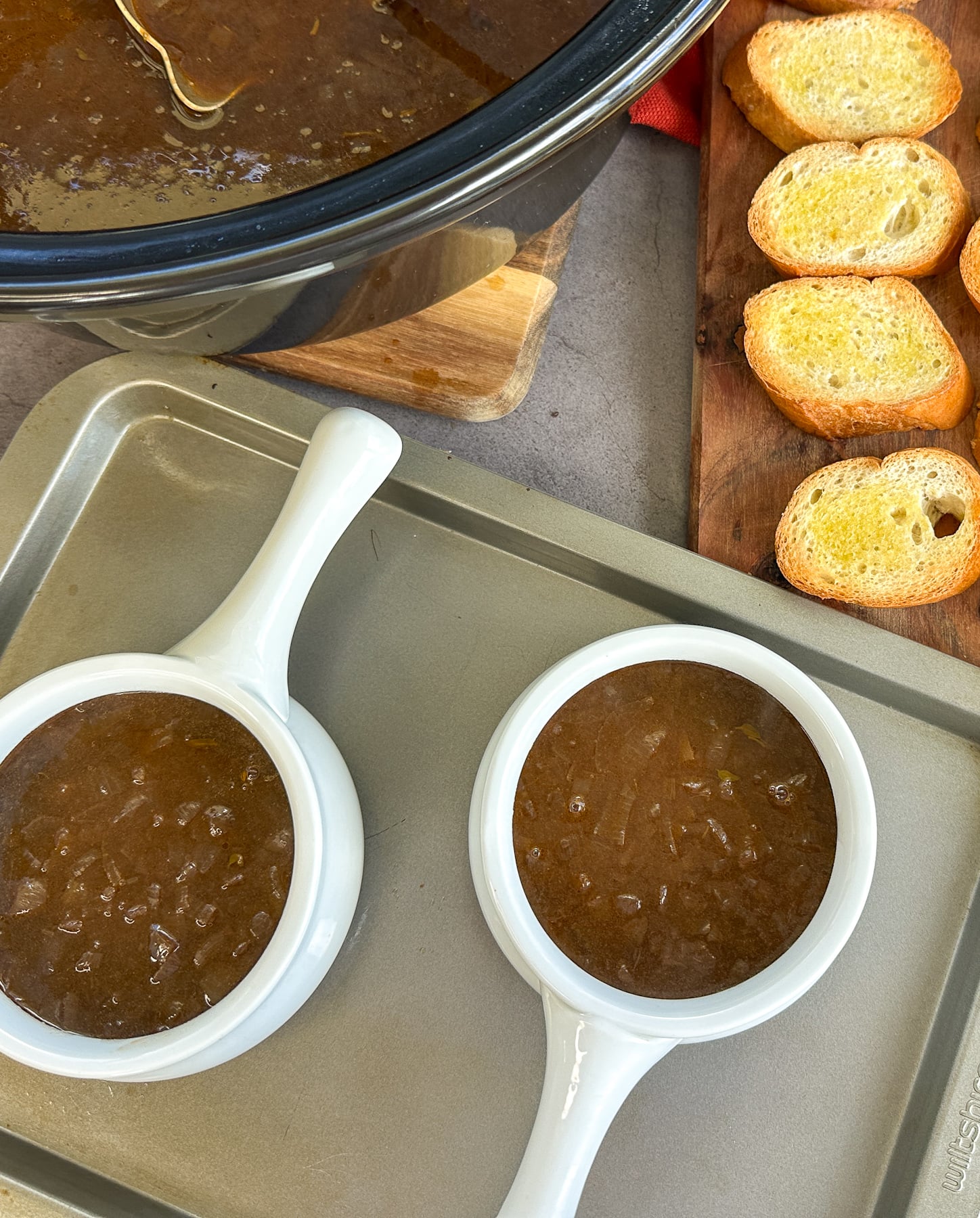 two white bowls filled with caramelized French onion soup