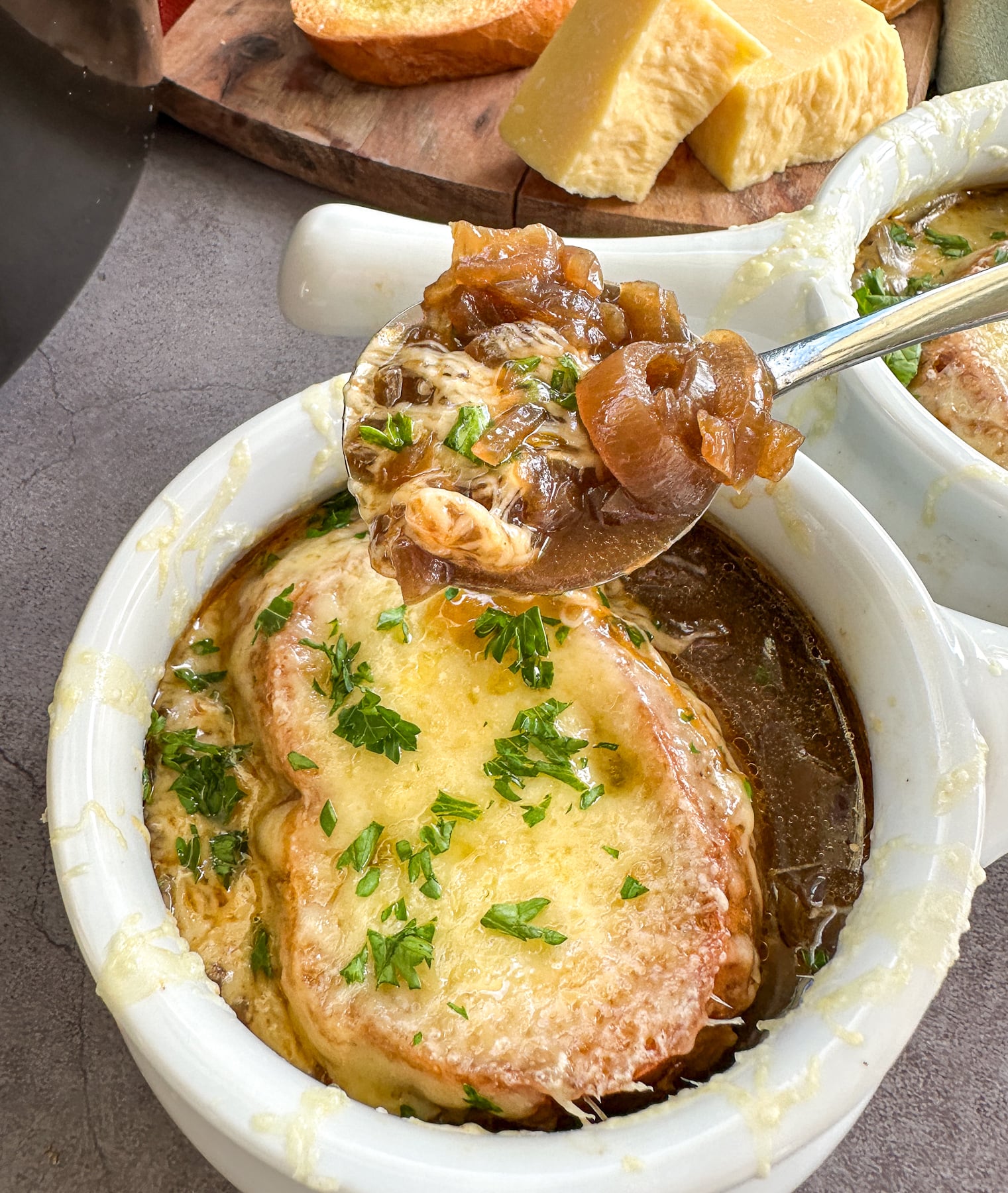 Spoonful of French onion soup from a fresh hot bowl