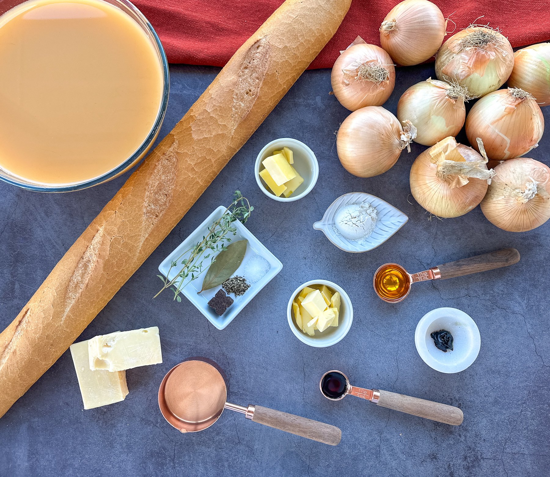 Ingredients I use to make French onion soup in the slow cooker including onions, beef stock baguette and cheese