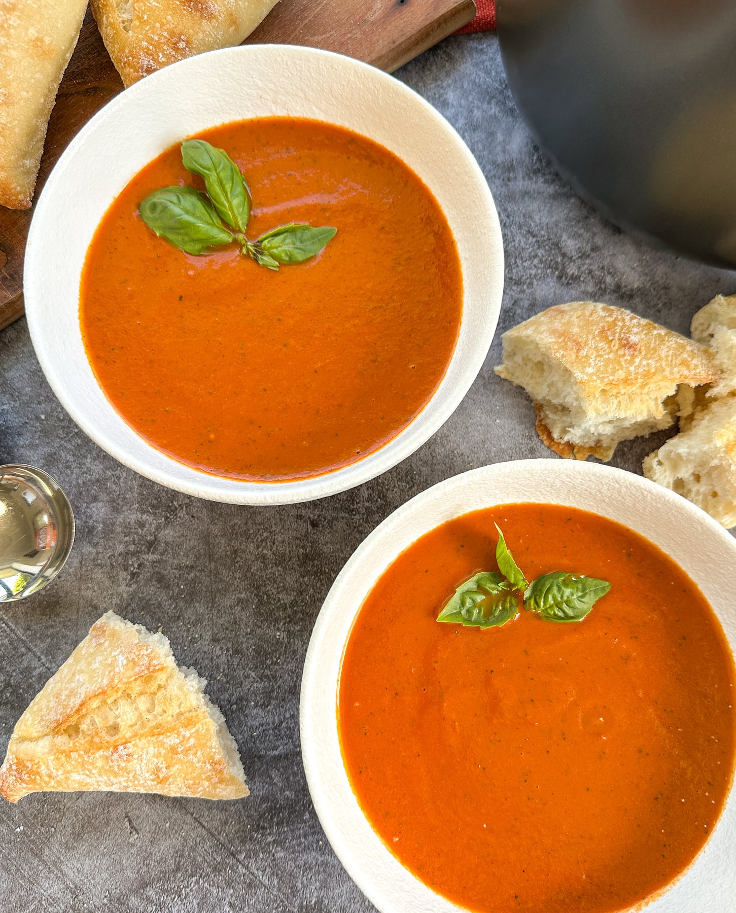 Two bowls of slow cooker tomato basil soup