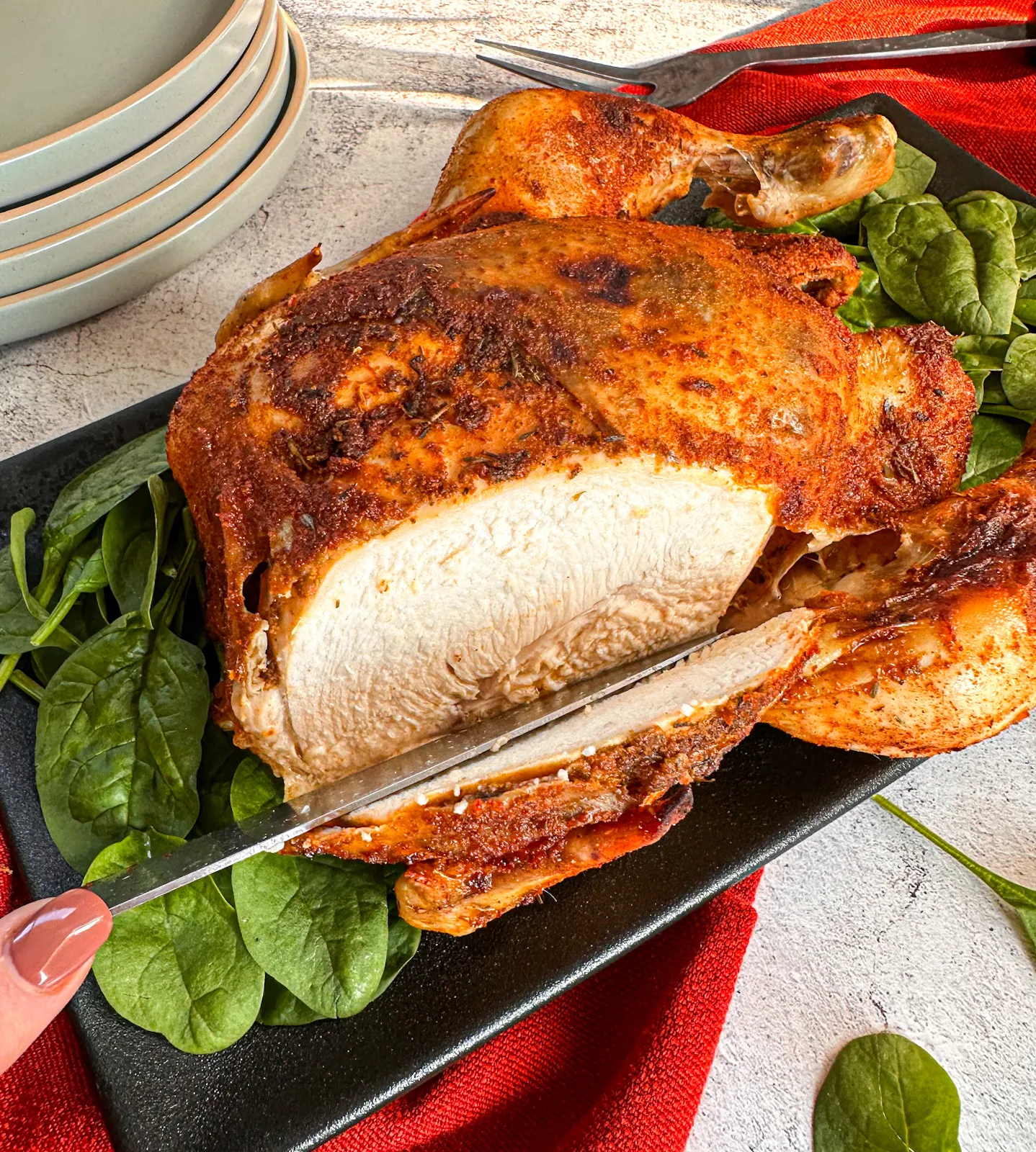 Slicing into a whole chicken that has been slow cooked in a rub
