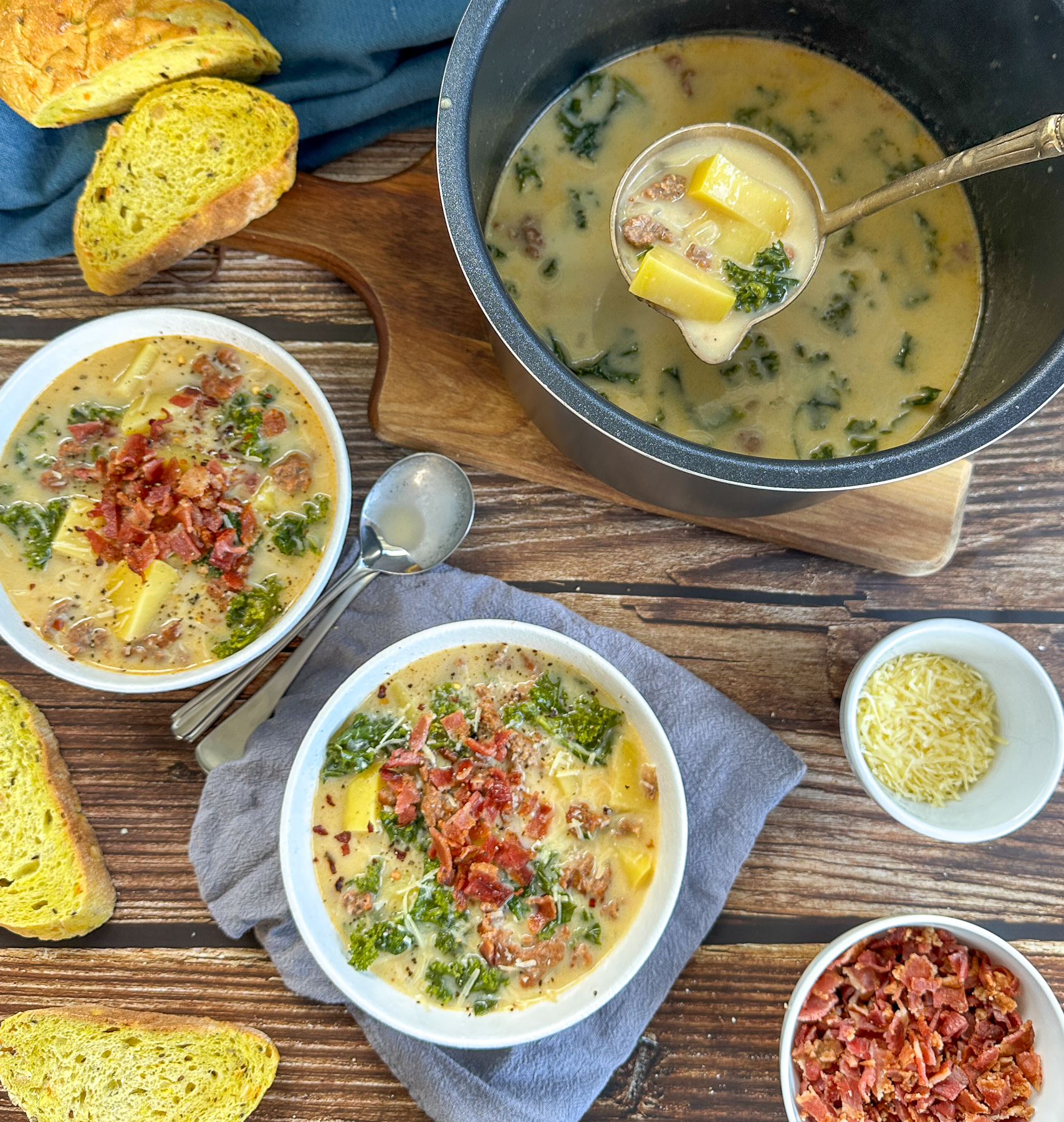 Slow cooker bowl full of Zuppa Toscana served with crispy bacon and parmesan cheese