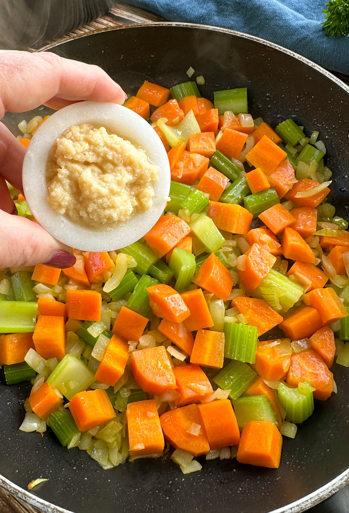 adding the garlic to the sautéed vegetables