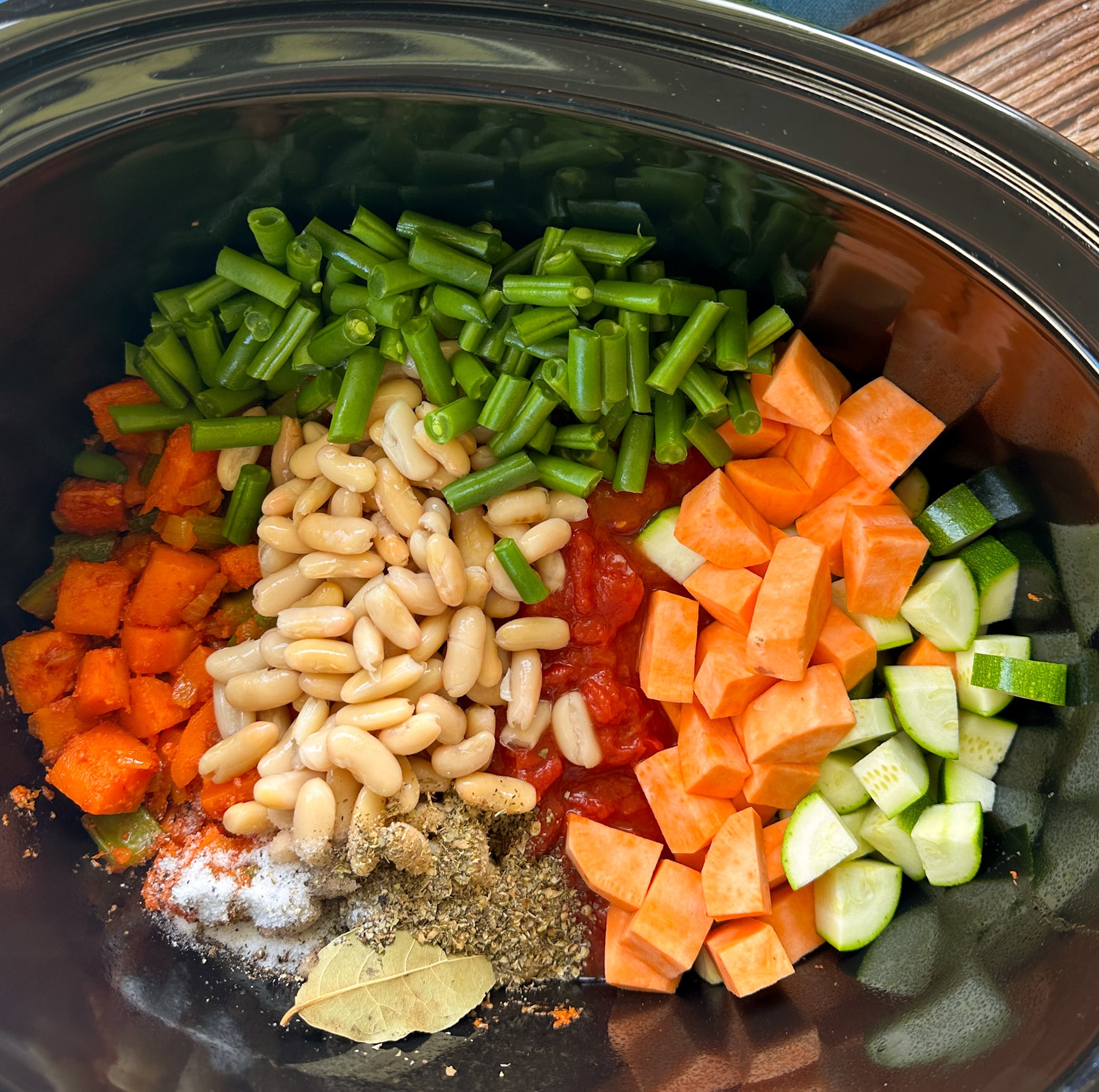 all of the ingredients for minestrone in the bowl of a slow cooker