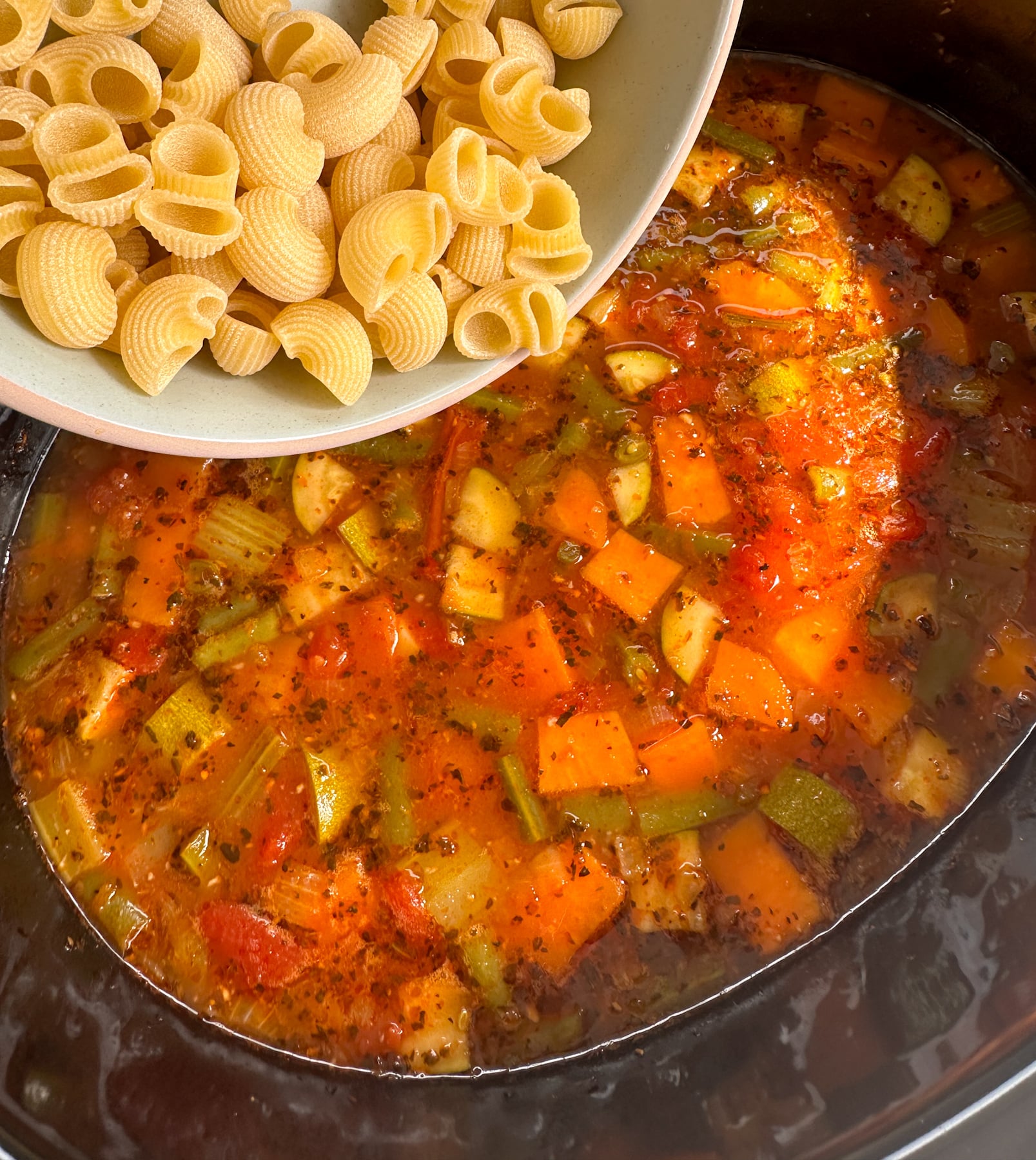 Adding the pasta to the minestrone vegetable soup