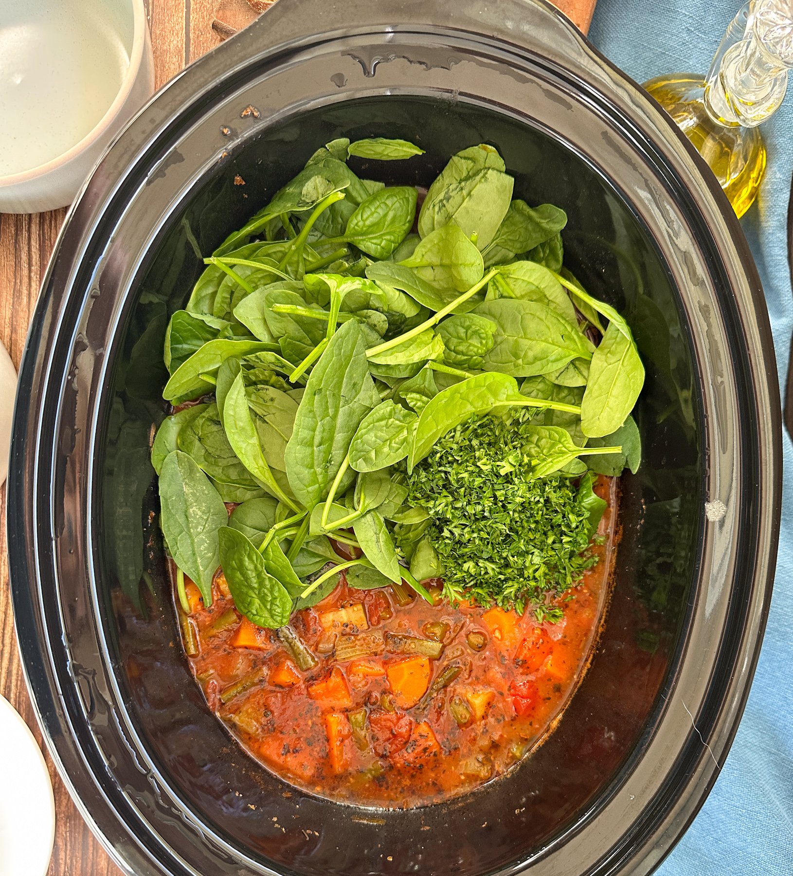 finish the minestrone by adding the spinach and parsley to the slow cooker