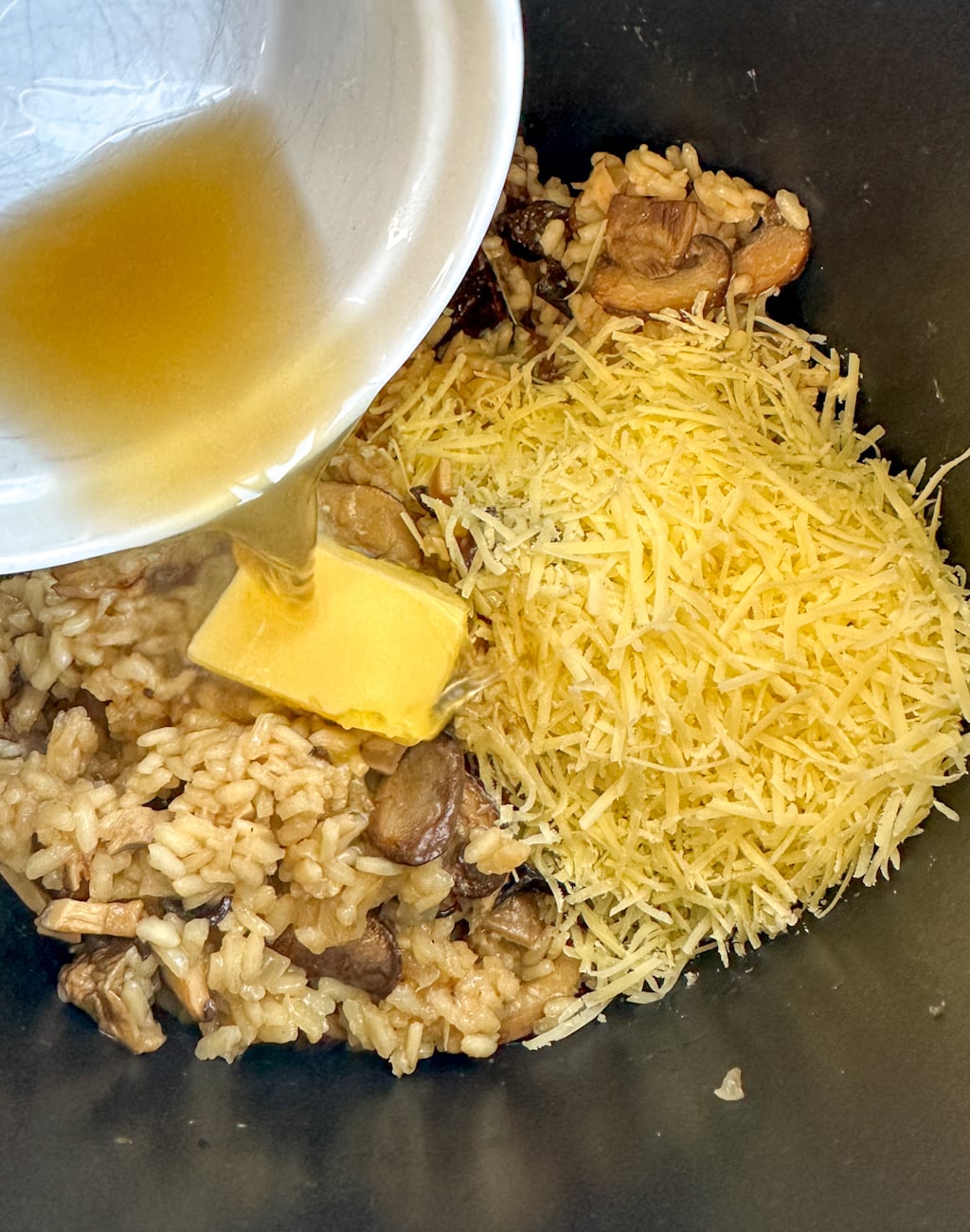 Adding stock, butter and parmesan to the risotto