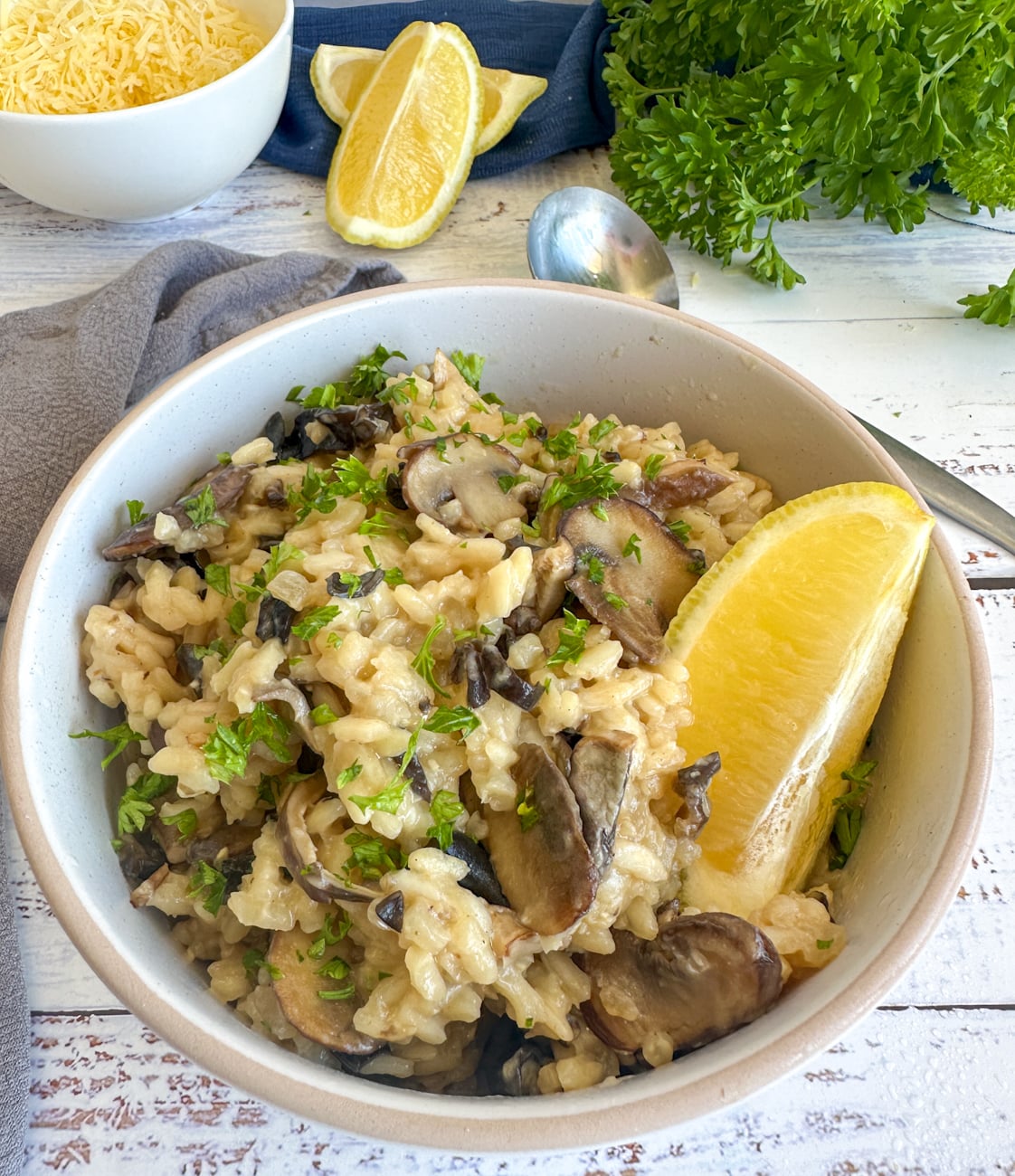 Bowl of slow cooker mushroom risotto with a wedge of lemon