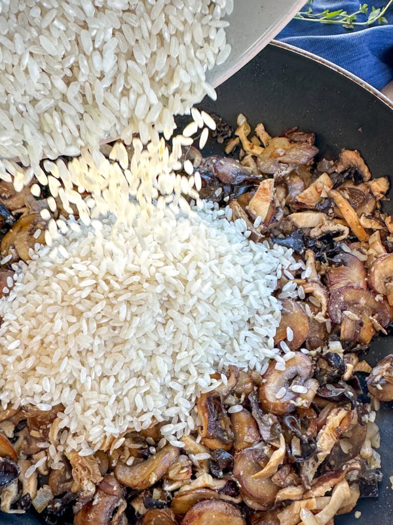 adding rice to the frying pan for risotto