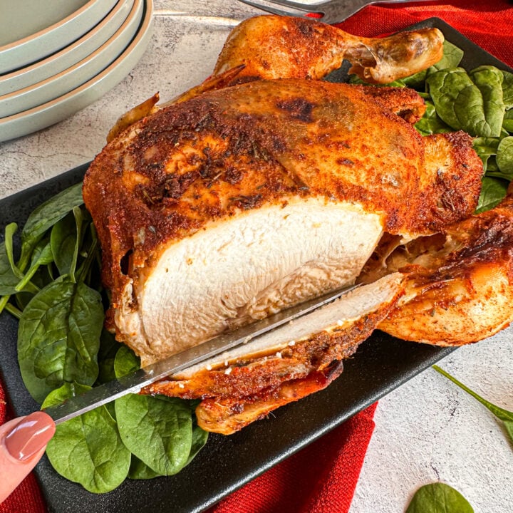 Slicing into a juicy whole chicken with crispy skin