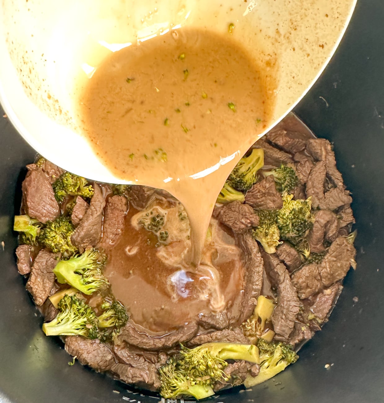 adding cornflour slurry to the beef and broccoli