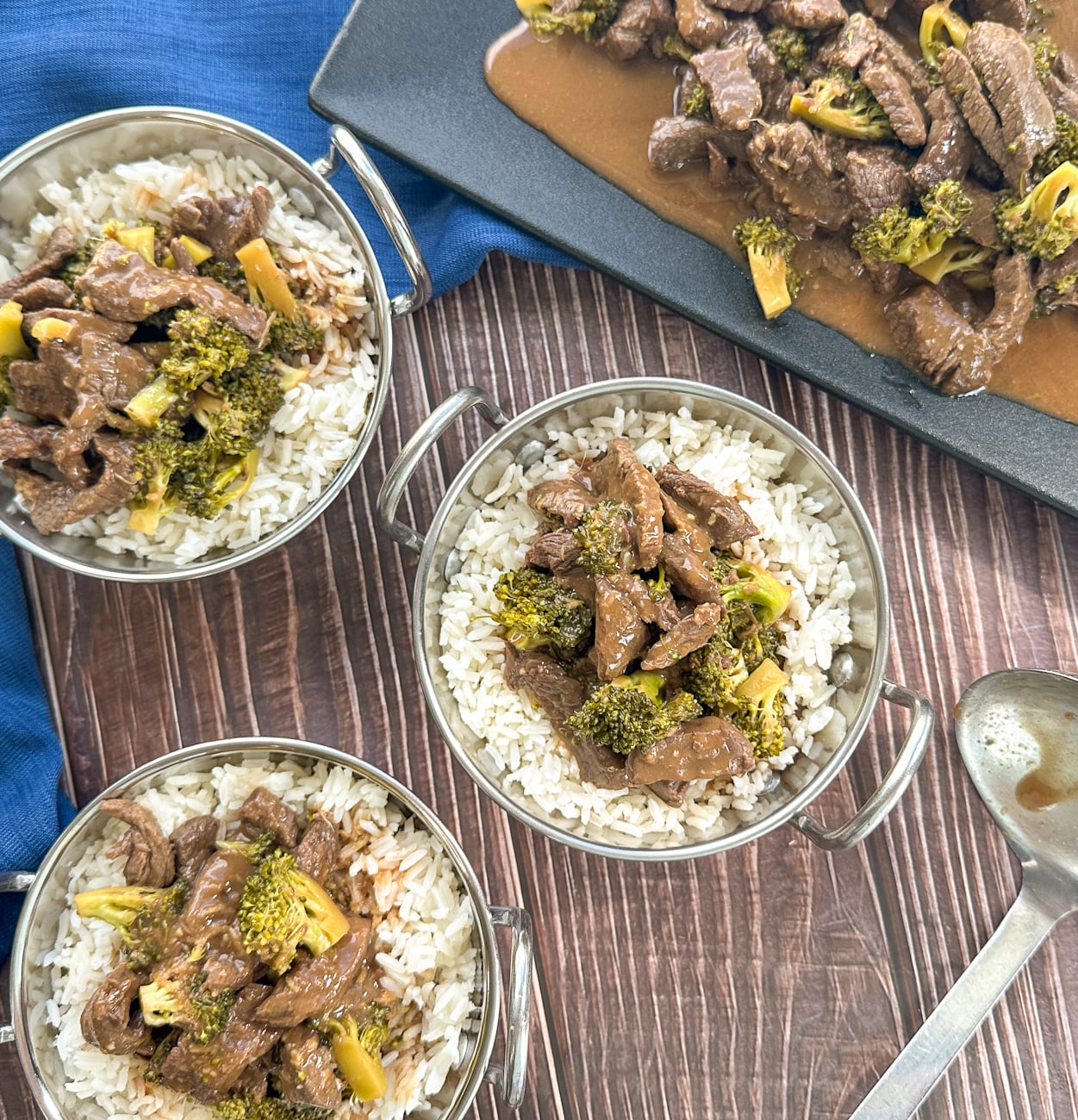 three bowls of takeaway style beef and broccoli over rice