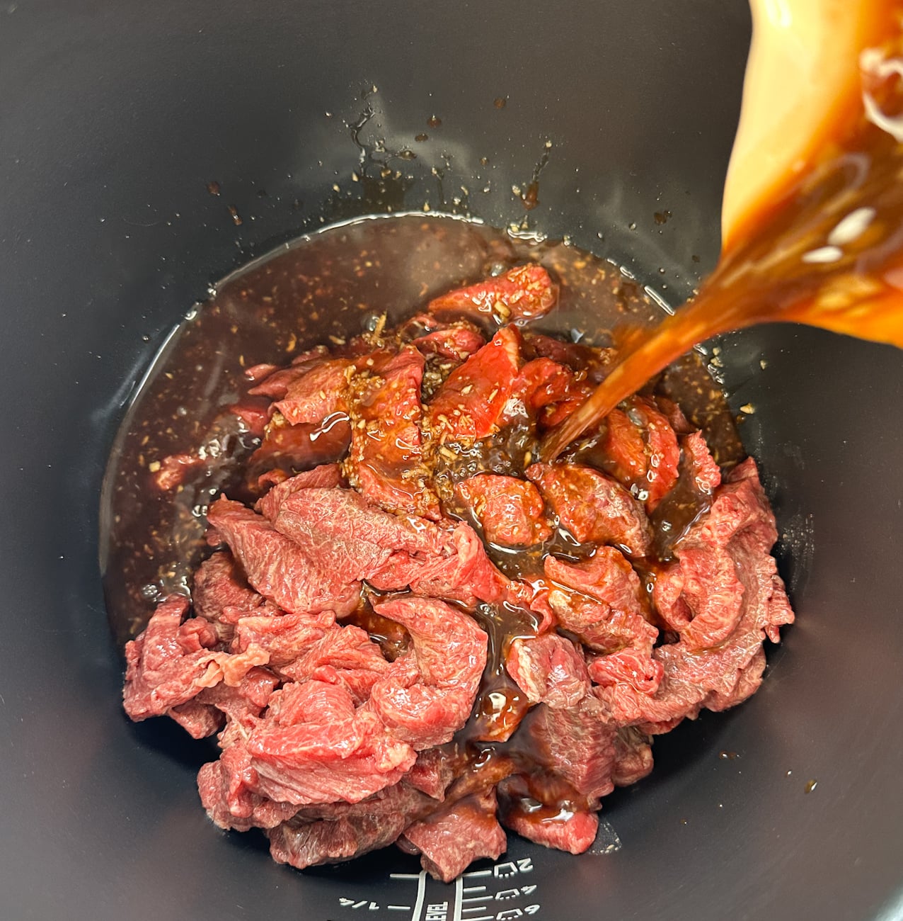 Adding the sauce to the slow cooker over the tender broccoli pieces