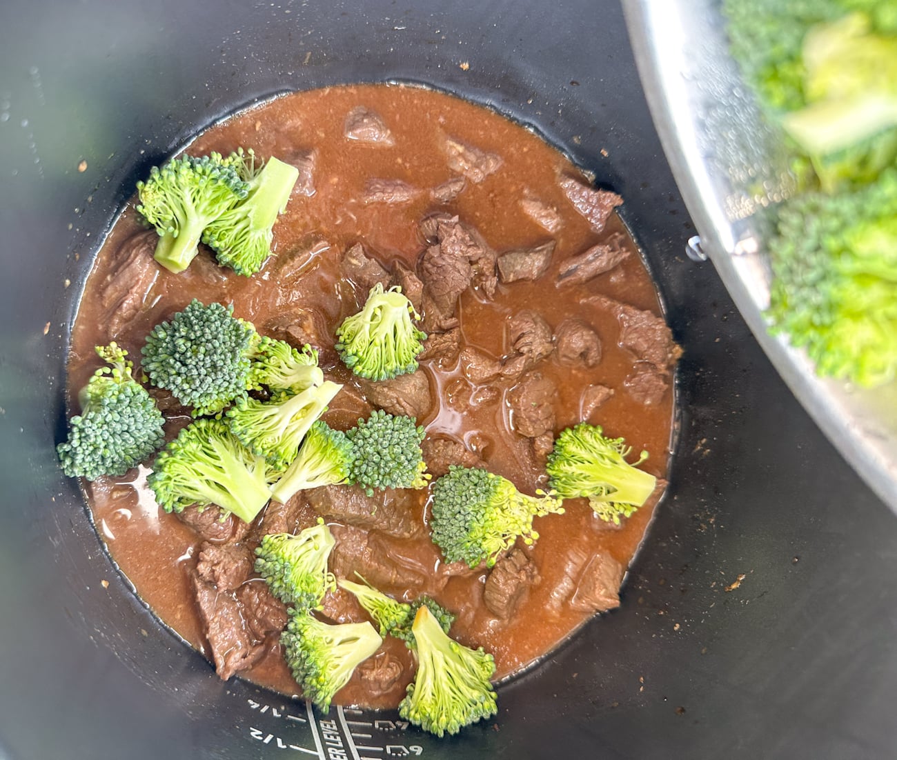adding the broccoli to the cooked beef at the end to keep it green