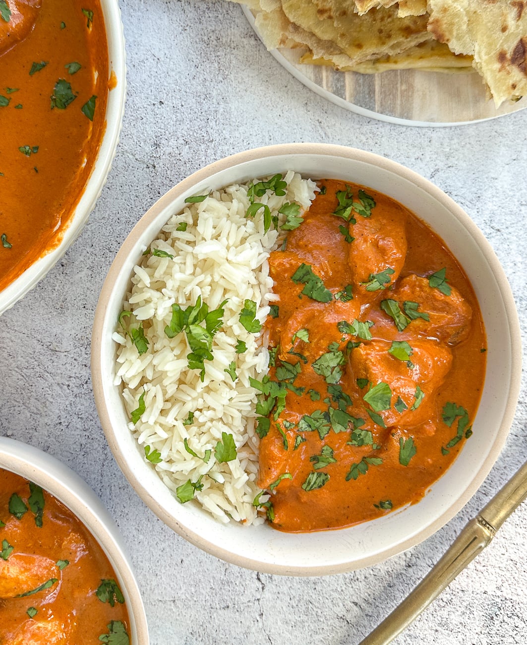 Slow Cooker butter chicken in a bowl with rice and coriander