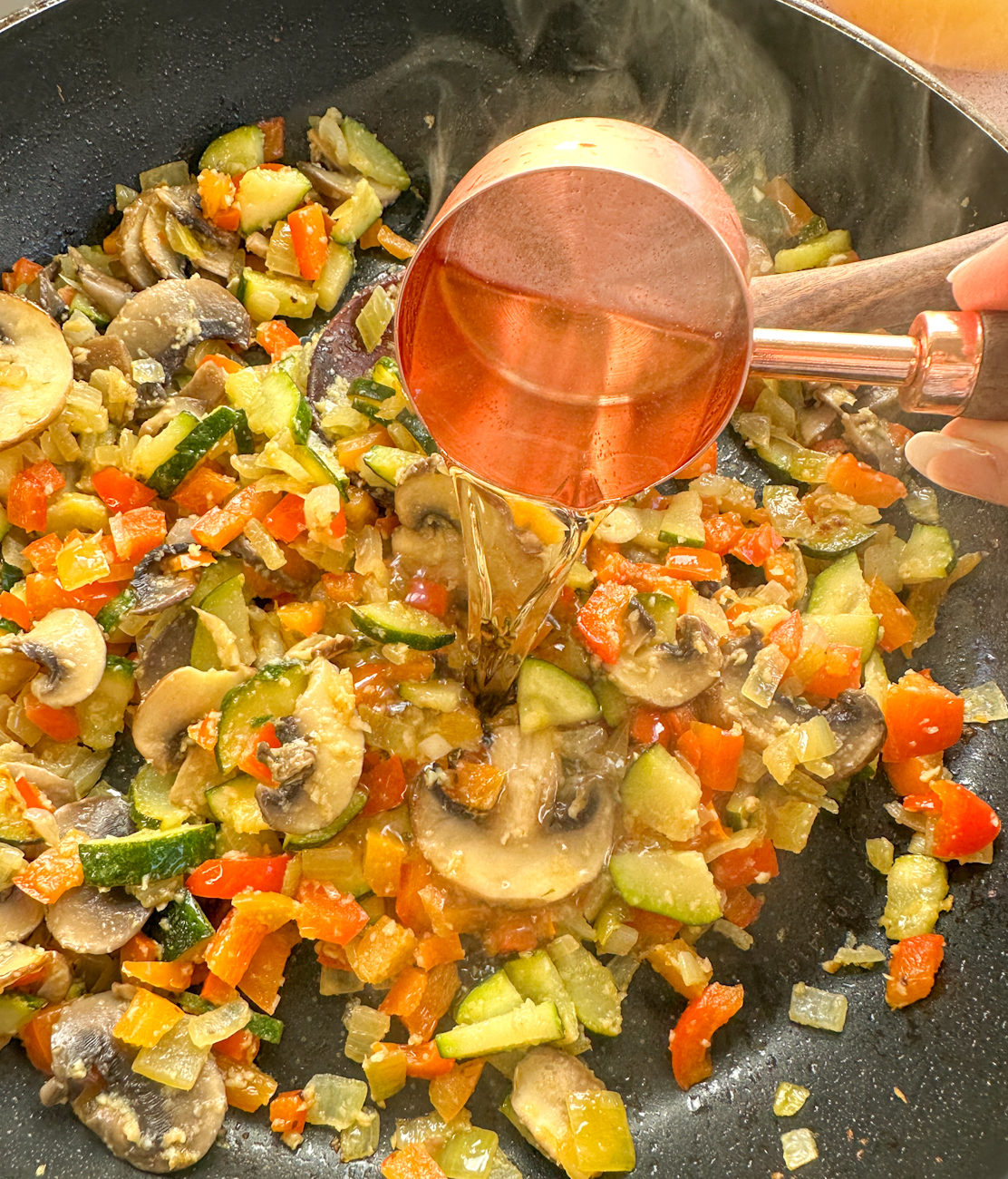 adding wine to the sauteed vegetables and herbs.