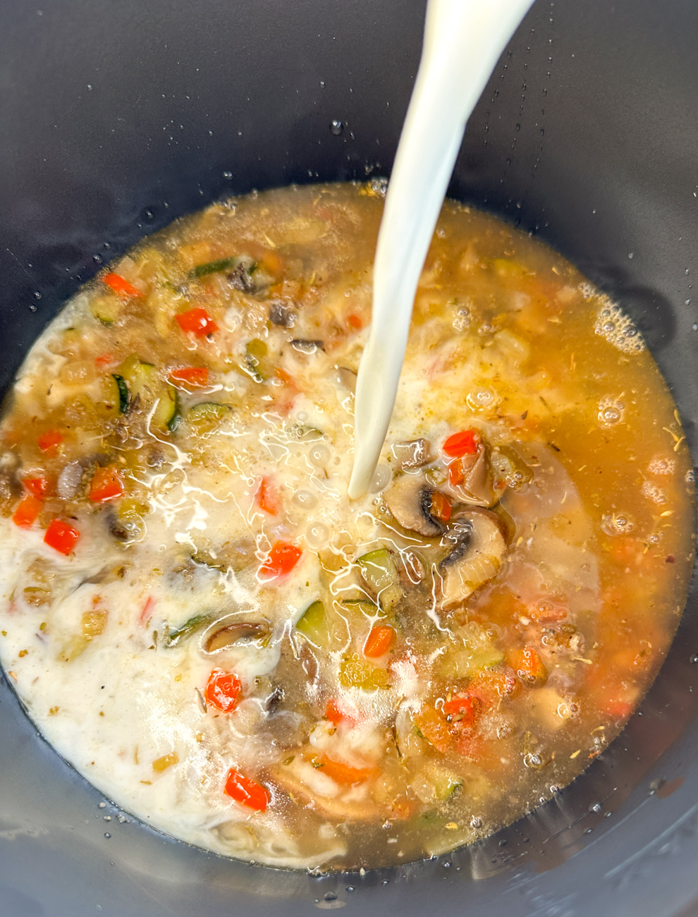 Pouring the cream into the slow cooker for alfredo