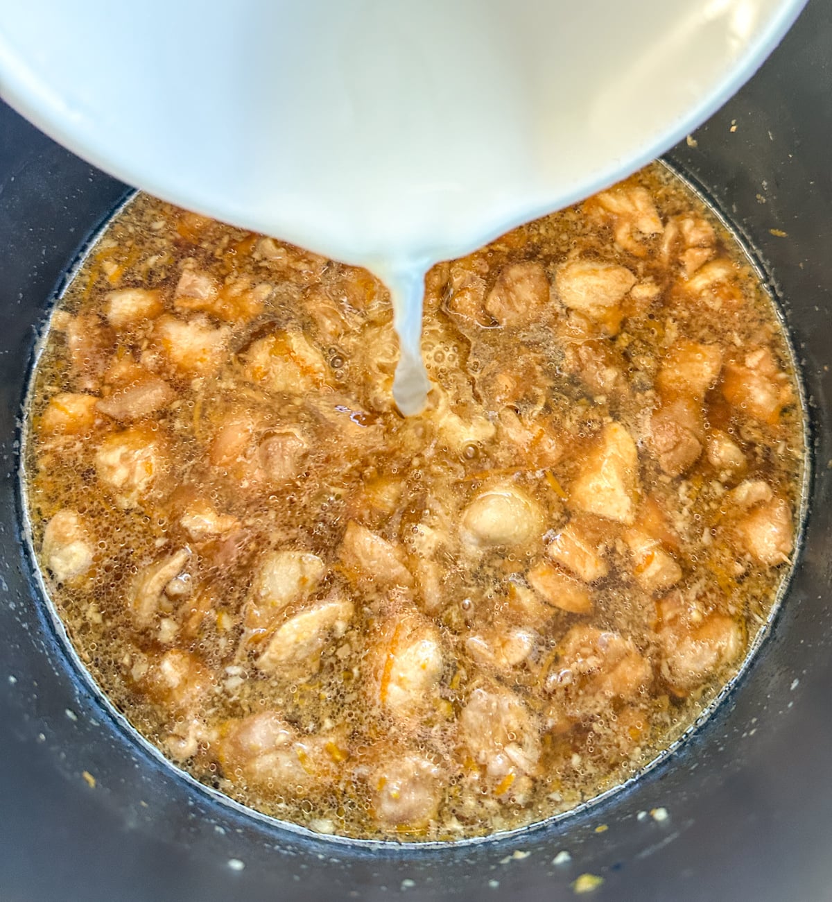 adding cornflour slurry to the slow cooker chicken