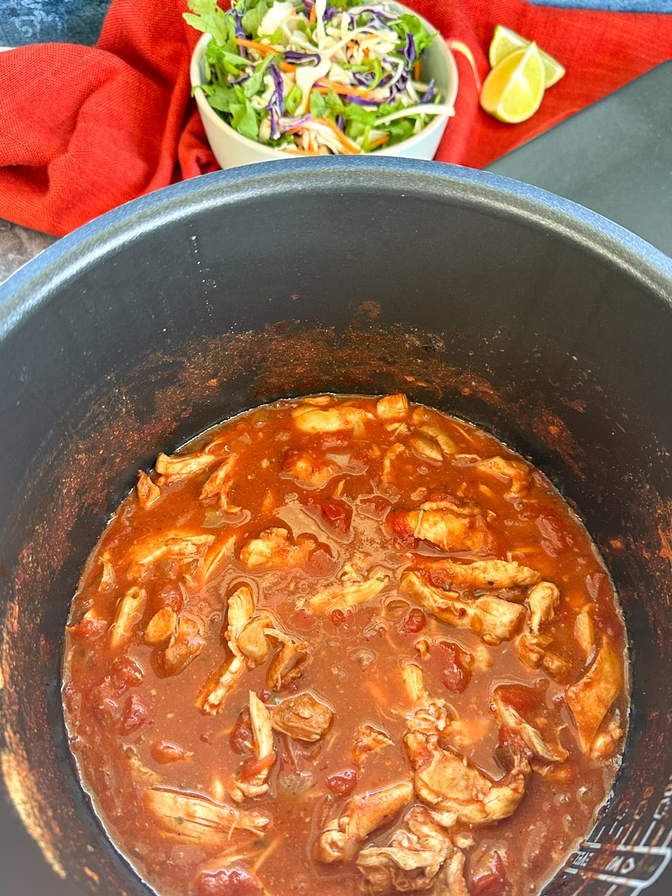 slow cooker with shredded chicken in a mexican inspired sauce