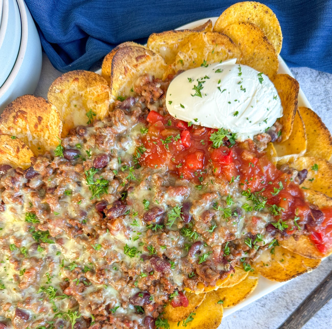 nachos fresh from the oven with sour cream and salsa