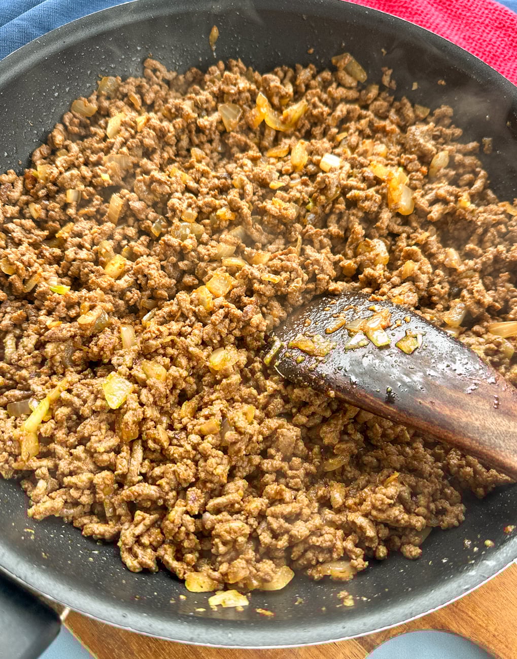 cooking the beef until brown and adding onions