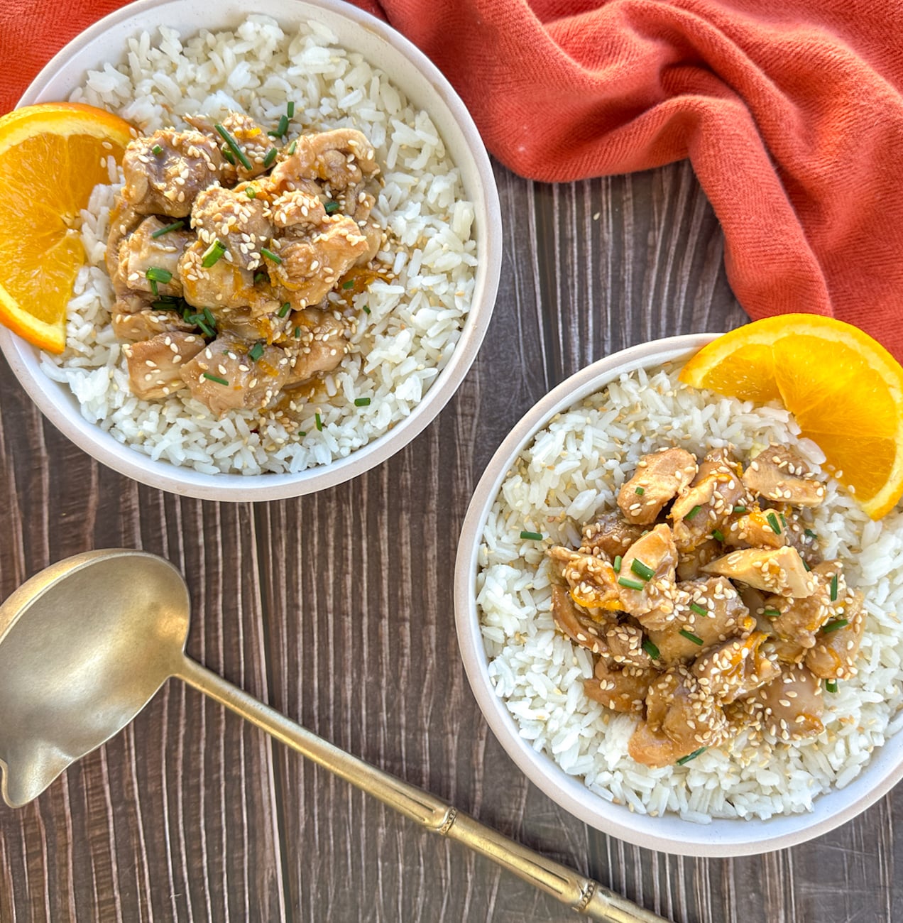 two bowls of rice with orange chicken spooned over the top