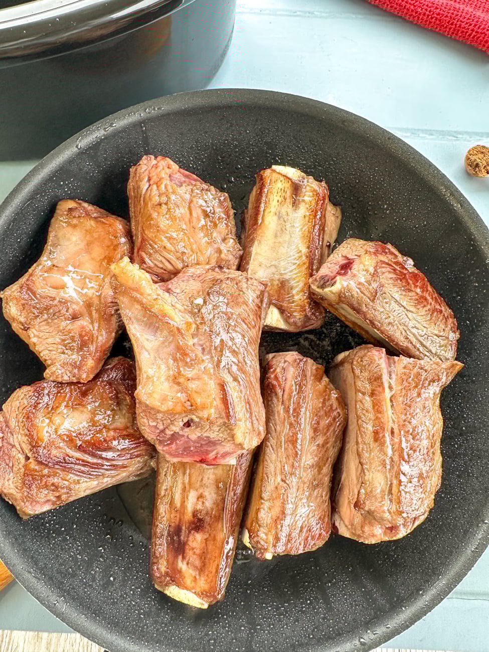 browning beef shortribs in a frying pan