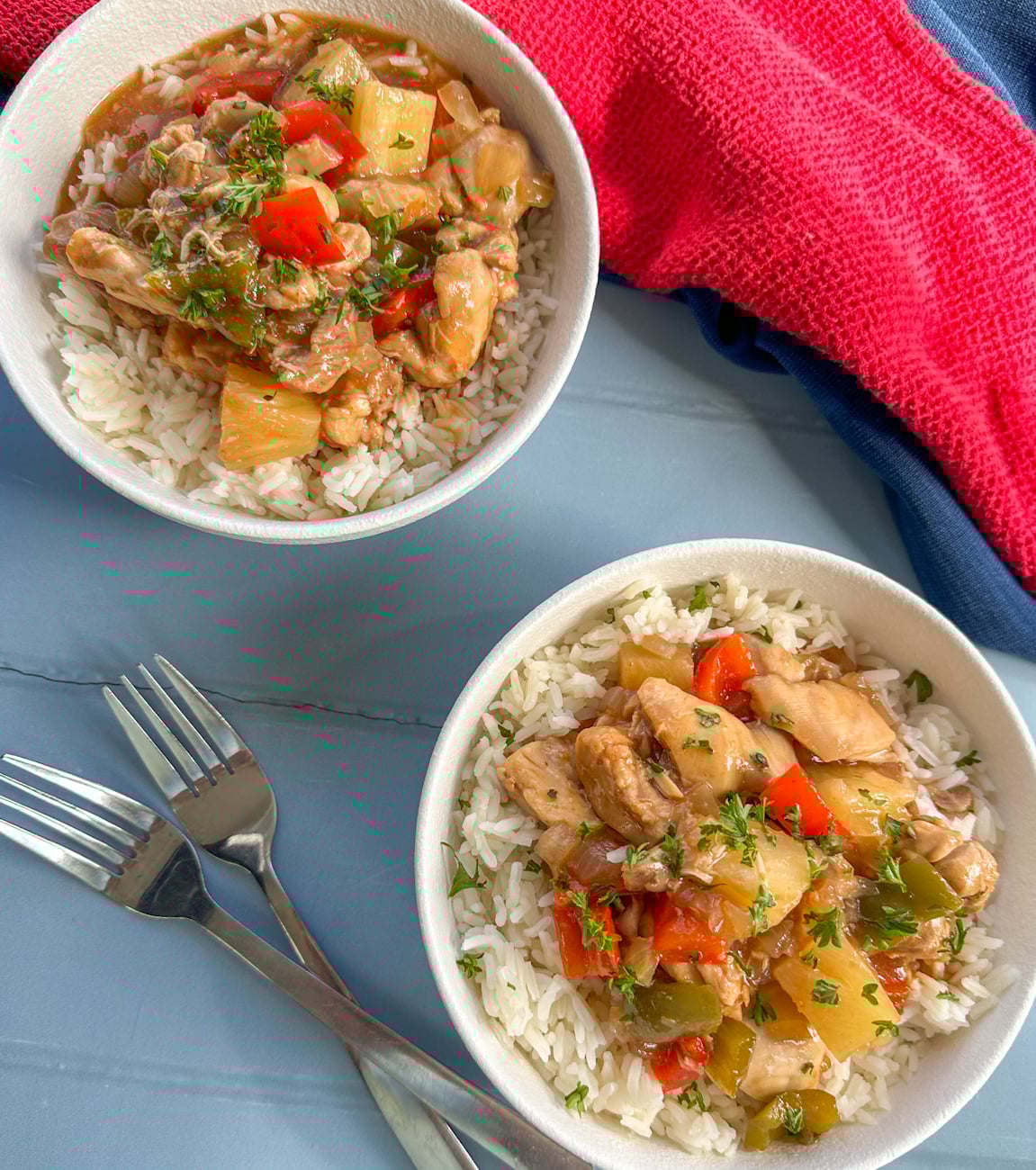 Two white bowls with rice and sweet and sour chicken