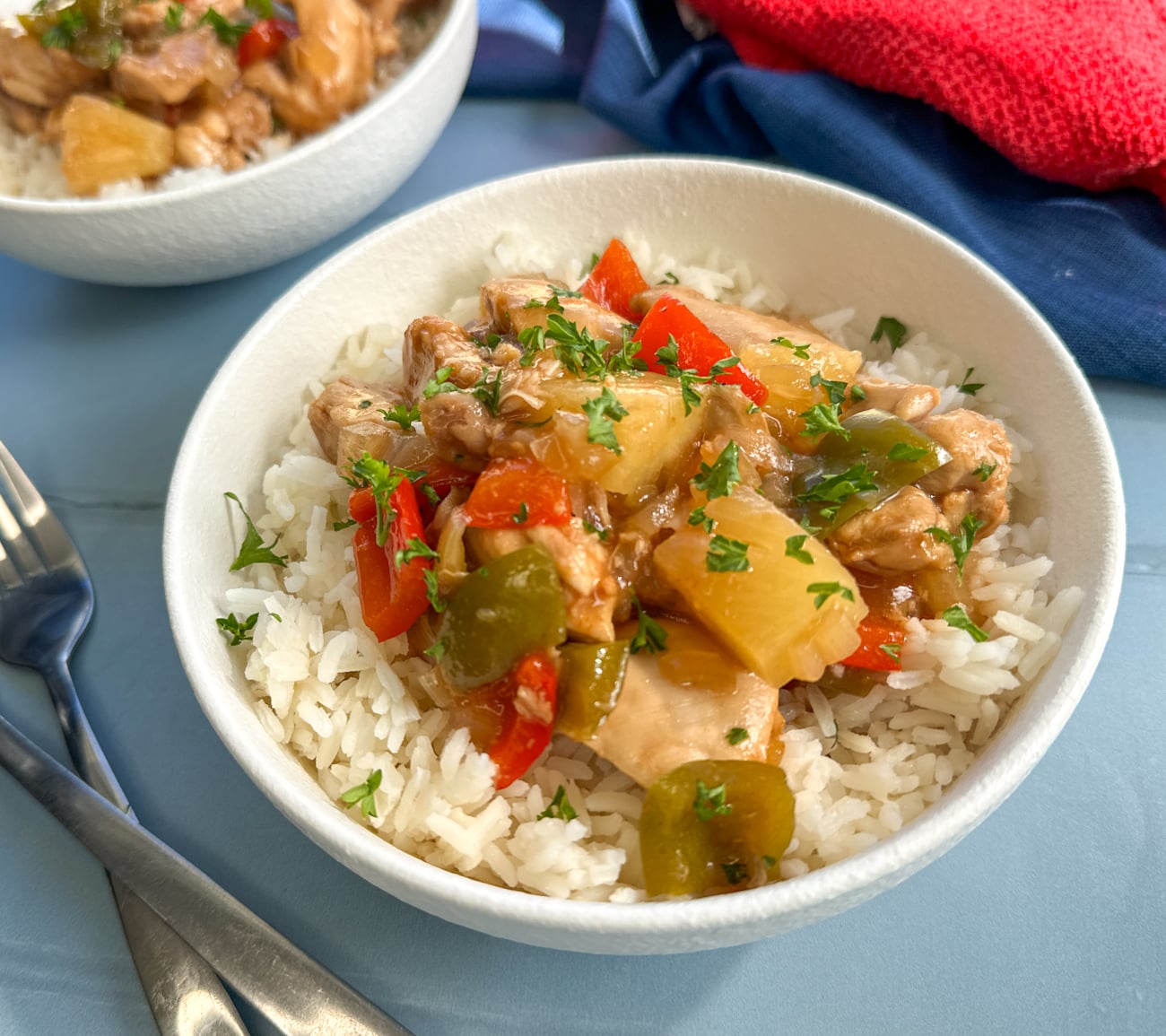 bowl of sweet and sour chicken with tender chicken and pineapple pieces