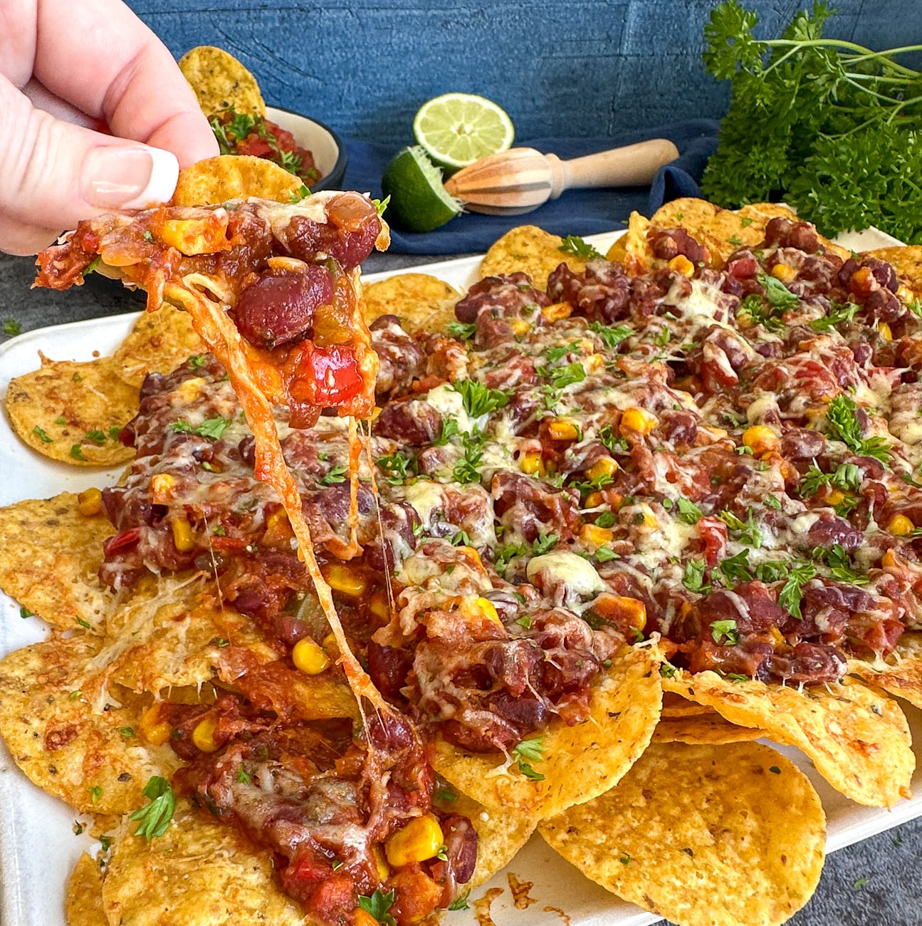 Scoop of chili nachos with melted mozzarella cheese