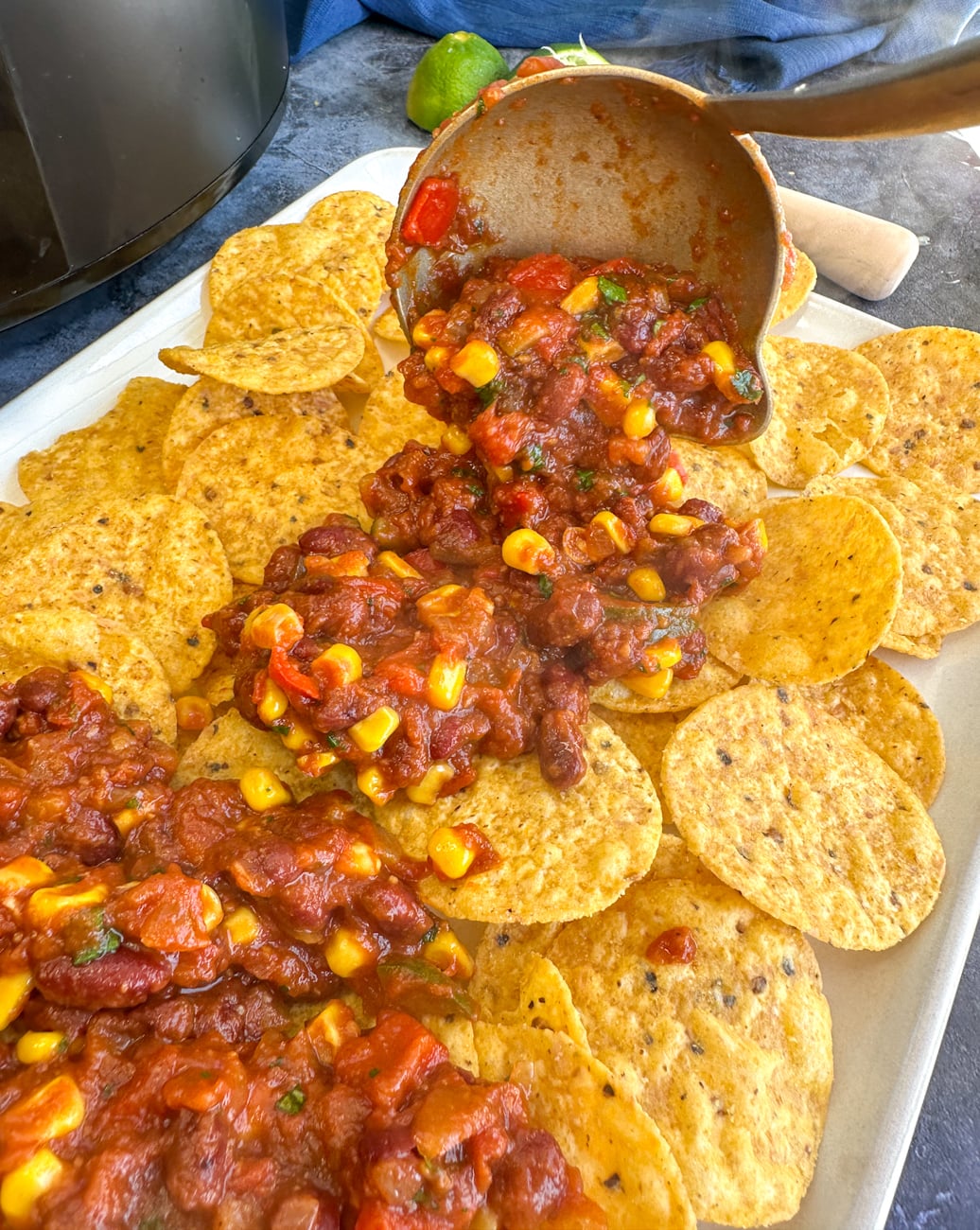 serving vegetarian chili on top of nacho tortilla chips