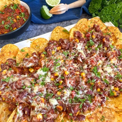 Slow Cooker Vegetarian Chili Nachos covered in cheese and parsley