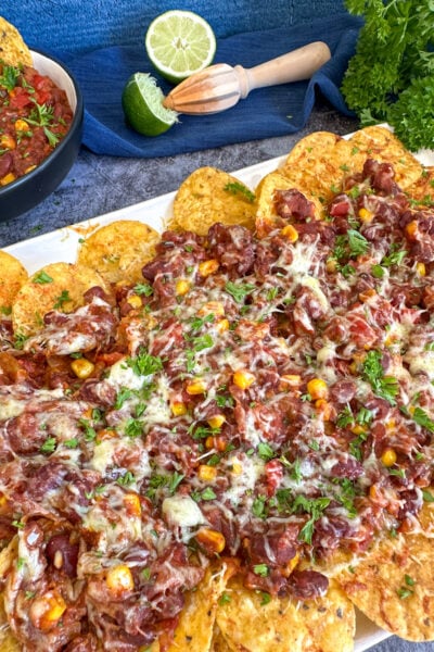 Slow Cooker Vegetarian Chili Nachos covered in cheese and parsley
