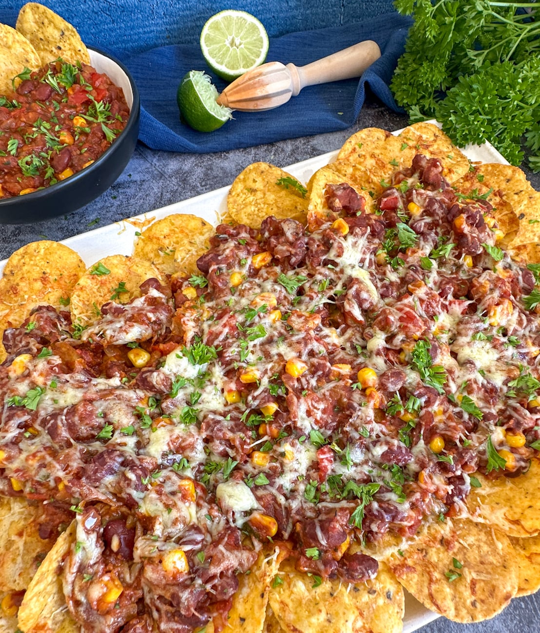 Slow Cooker Vegetarian Chili Nachos covered in cheese and parsley