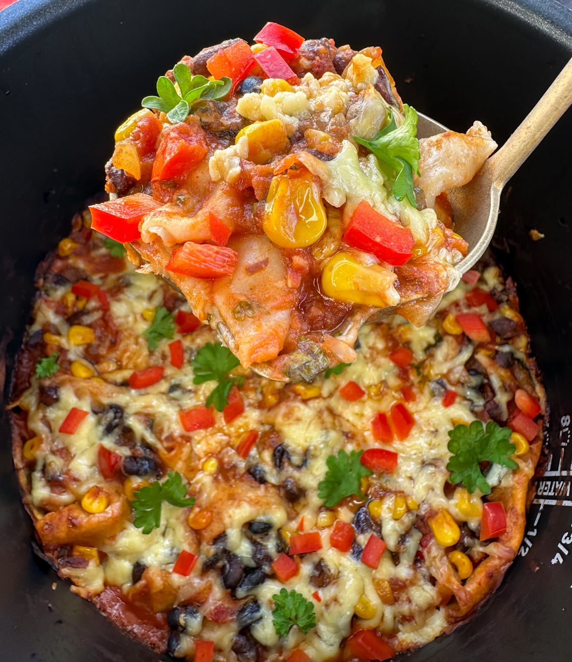 Ladle full of slow cooker vegetarian enchilada casserole
