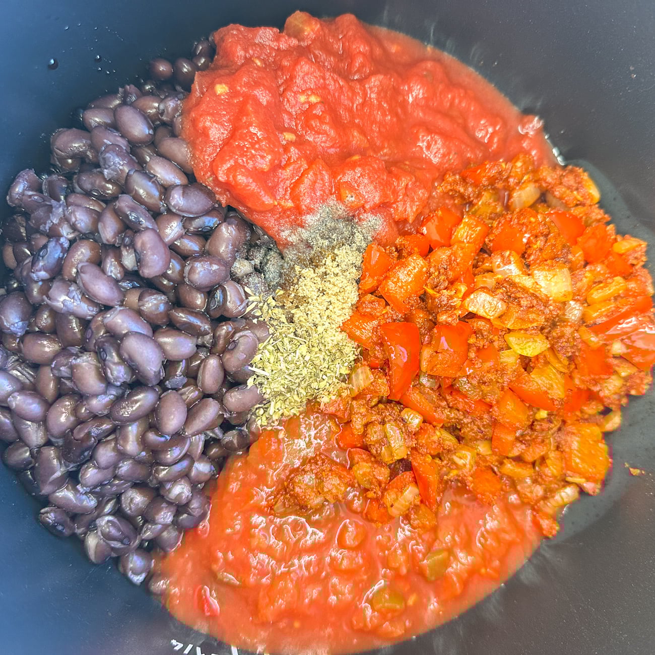 adding the ingredients to the slow cooker for the enchilada casserole