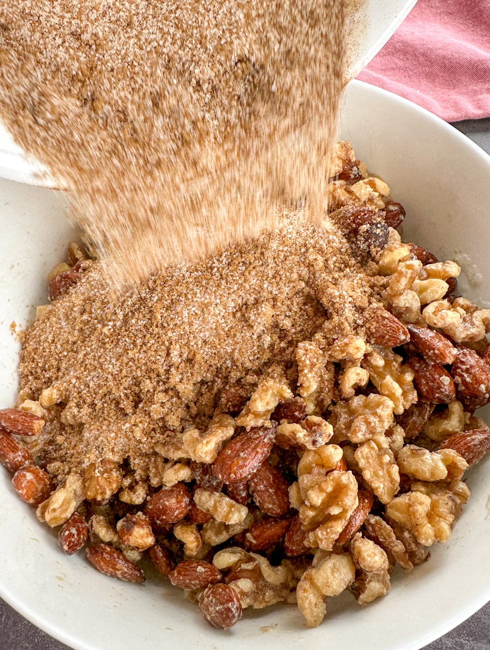 coating mixed nuts in a sugar spice mix