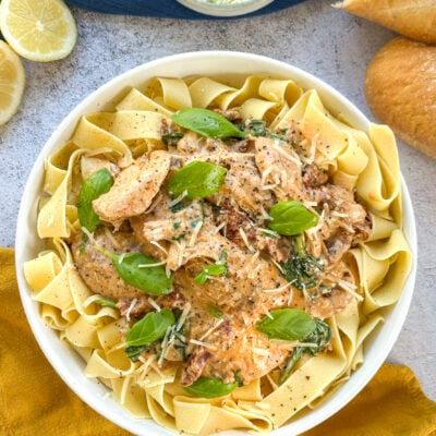 Creamy slow cooker tuscan chicken served over pappardelle