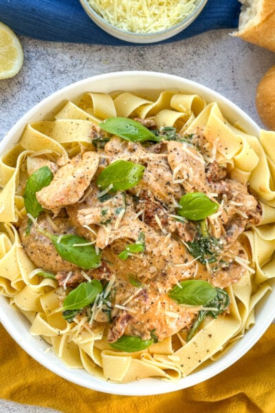 Creamy slow cooker tuscan chicken served over pappardelle