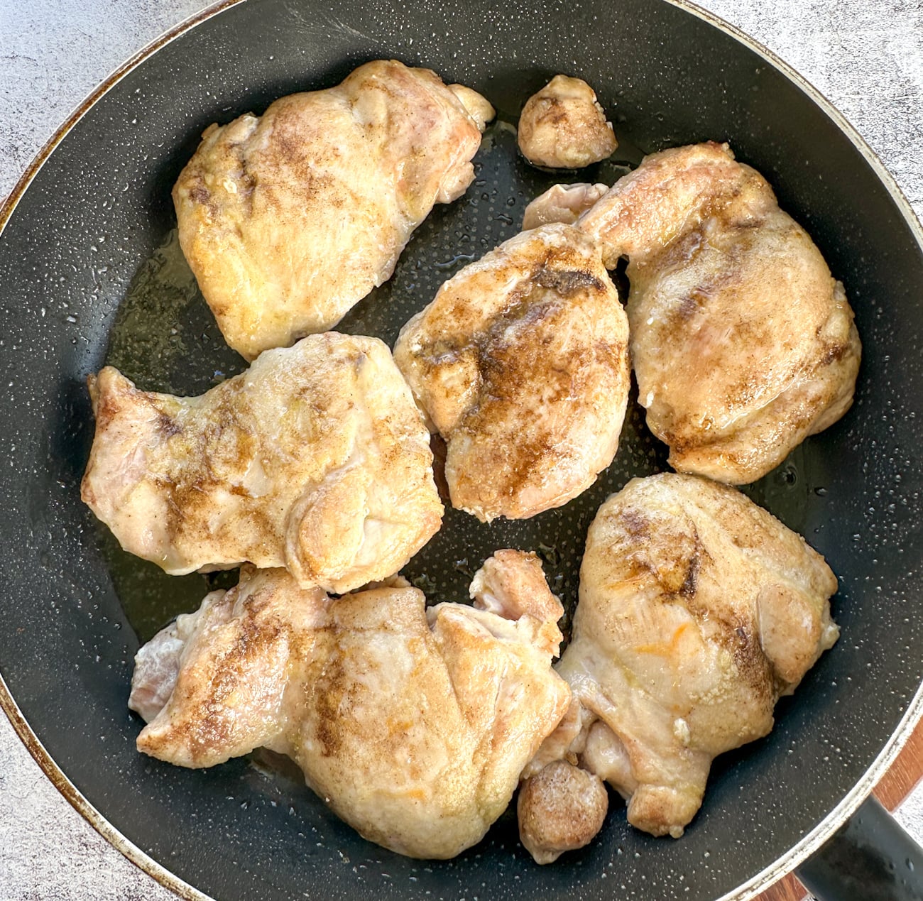 searing flour coated chicken in a frying pan